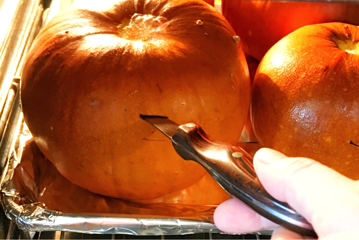 poking a knife into a pumpkin